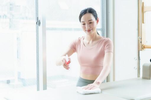 ピラティスマシンをクリーニングする女性 ピラティス,女性,ピラティスマシンの写真素材