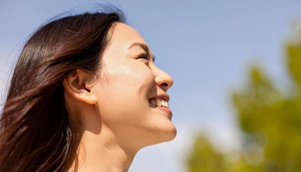 上を向いた日本女性の笑顔の横顔 上を向いた日本女性の笑顔の横顔の写真