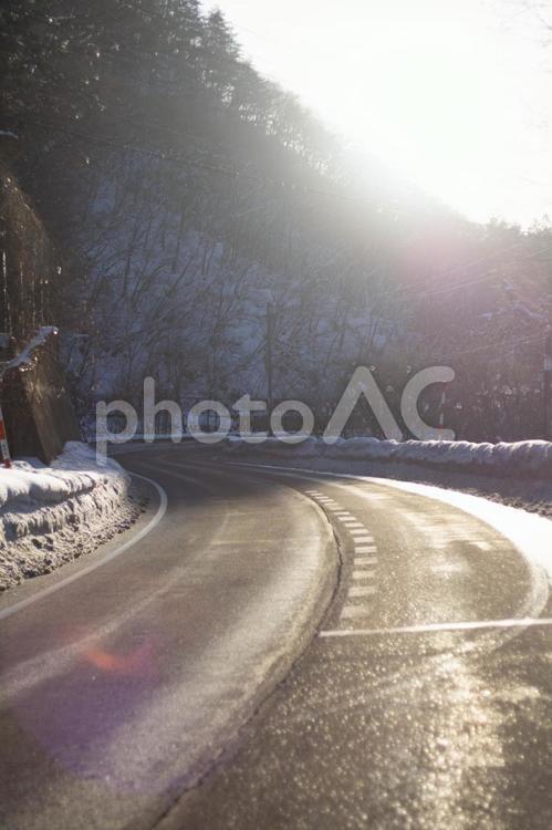 朝日が昇る冬の国道48号線 国道48号,関山峠,雪道の写真素材
