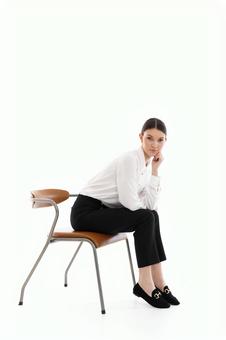 頬杖をしてカメラ目線で座る女性 頬杖をしてカメラ目線で座る女性の写真
