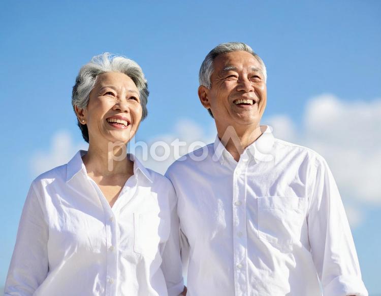 晴天の下、希望に満ちた表情のシニア夫婦 シニア,夫婦,白シャツの写真素材
