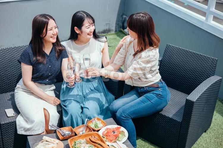 屋上でパーティーをする女性たち（シャンパンで乾杯） 女子会,パーティー,シャンパンの写真素材