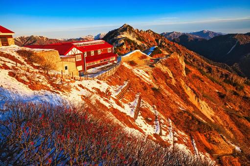 朝焼けの冠雪の北アルプスの燕岳と燕山荘 朝焼け,モルゲンロート,北アルプスの写真素材