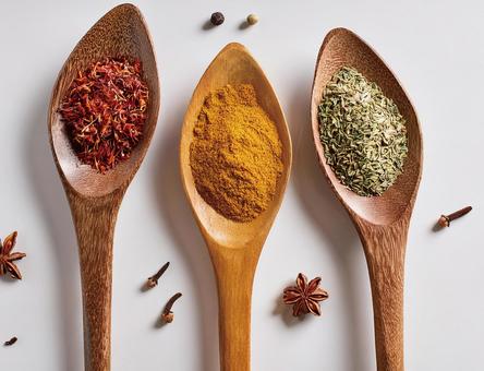 木のスプーンに乗せたスパイスの写真