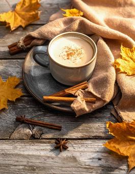 木目のテーブル上のカフェラッテと紅葉 木目のテーブル上のカフェラッテと紅葉の写真