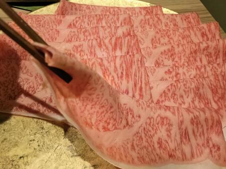 箸で摘まんだしゃぶしゃぶ用の薄切り肉 箸で摘まんだしゃぶしゃぶ用の薄切り肉の写真
