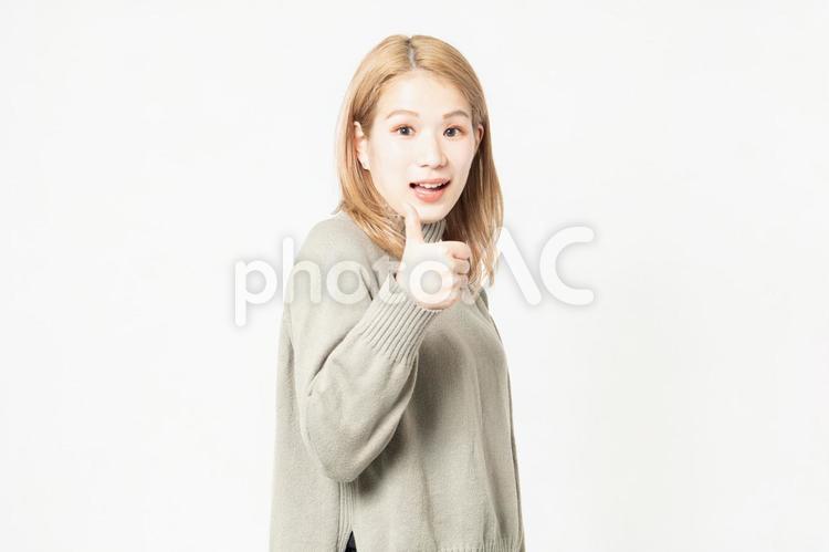 いいねのポーズをするセーターを着た若い女性 いいね,親指,女性の写真素材