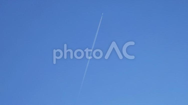 Airplane flying while emitting contrails 飛行機雲,飛行機,旅客機の写真素材