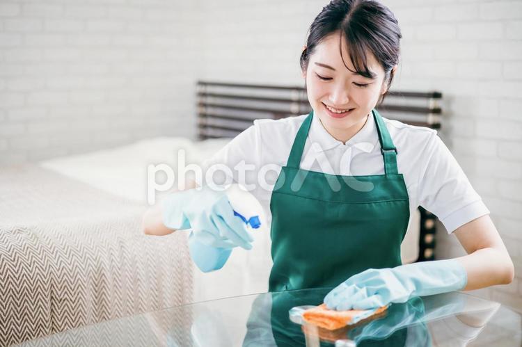 テーブルの掃除をするハウスキーパーの女性 ハウスキーパー,ハウスクリーニング,掃除の写真素材