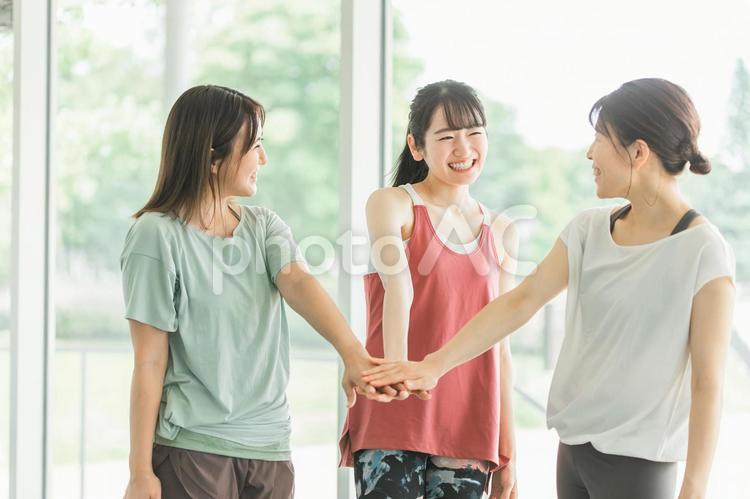 ジムで仲間と円陣を組むアジア人の女性達 ヨガ,スポーツジム,ピラティスの写真素材