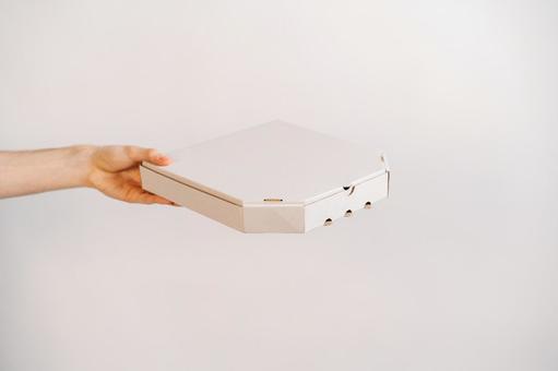 片手でピザ箱を差し出す 配達,フードデリバリー,テイクアウトの写真素材