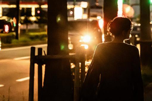 夜の歩道をあるく女性 夜の歩道をあるく女性の写真