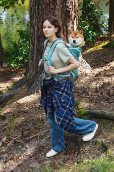 木の前に立つ女性キャンパーの写真