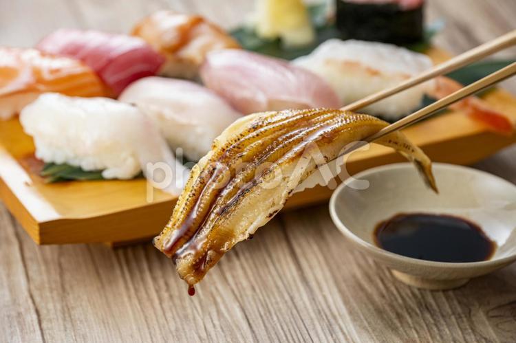皿に盛られた美味しそうな寿司を箸でつまむ 寿司,お寿司,握りの写真素材
