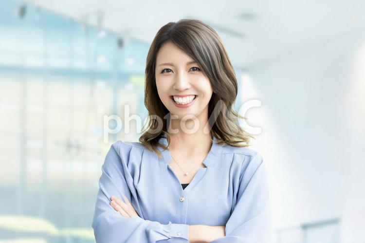 腕を組んで微笑む女性・ビジネスウーマン 女性,笑顔,微笑むの写真素材