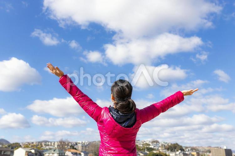 空に向かって両手を広げる女性 女性,人物,日本人の写真素材