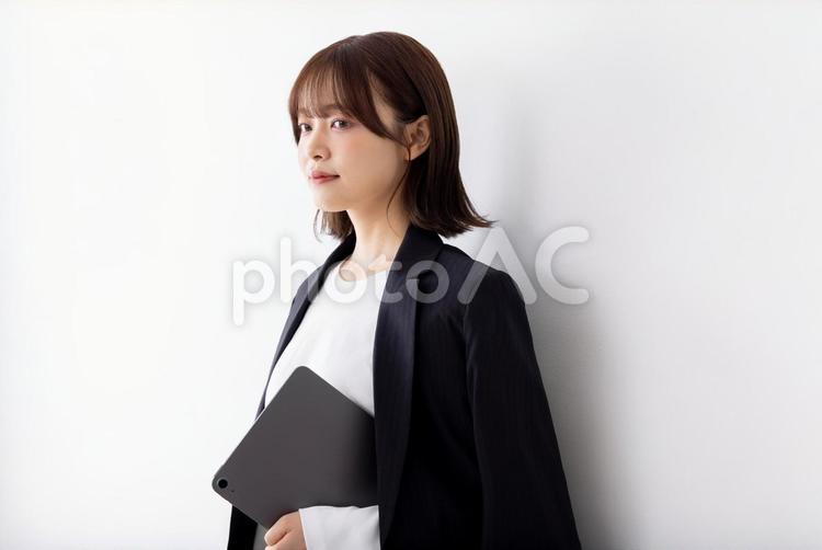 スーツを羽織るビジネスウーマン 女性,ビジネスウーマン,タブレットの写真素材