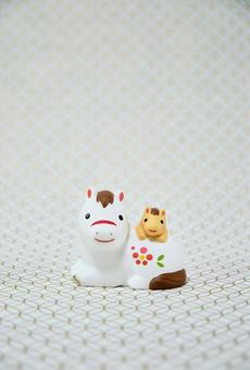 可愛い馬の置物と七宝柄の背景の年賀状素材の写真