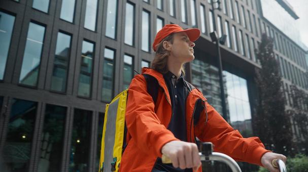 自転車に乗るフードデリバリーの男性の写真