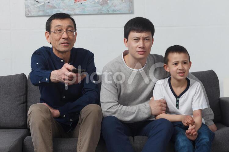 テレビを見る三世代のアジア人ファミリー2 アジア人,テレビを見る,家族の写真素材