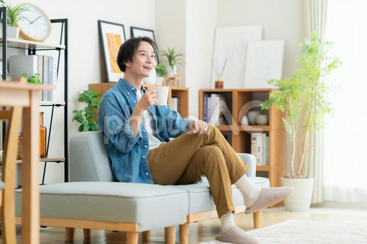 リビングでくつろぐ若い男性 男性,ライフスタイル,リビングの写真素材