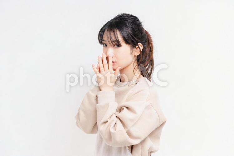 白い背景の前に立ってポーズをとる若い女性 女性,白背景,立つの写真素材