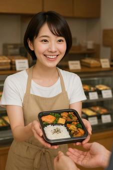 お弁当やさんで働く素敵な笑顔の女性 お弁当やさんで働く素敵な笑顔の女性の写真