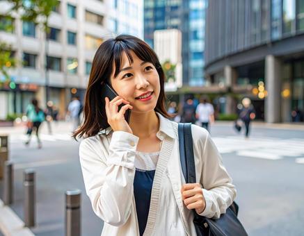 街中で電話をかける女性 街中で電話をかける女性の写真