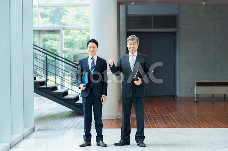 オフィスの廊下に立つビジネスパーソン ビジネスマン,笑顔,ビジネスパーソンの写真素材