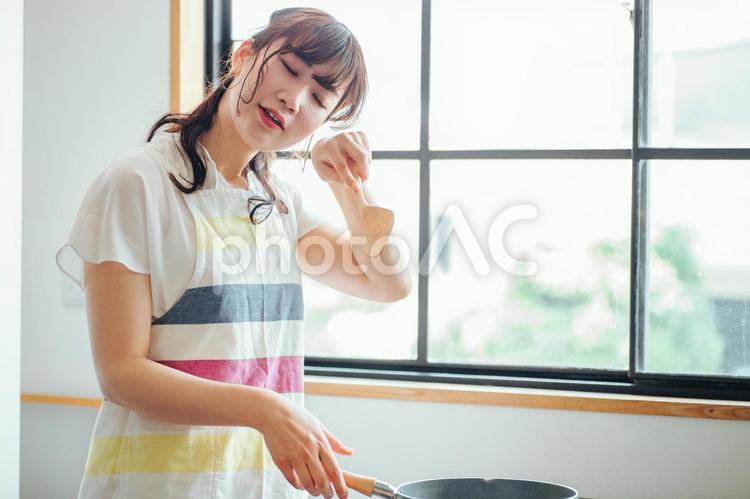 キッチンでフライパンを使う女性（疲れる） 料理,調理,疲労の写真素材