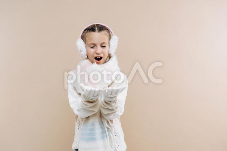 イヤーマフ・マフラー・手袋を身に着けて手を前に出している女の子 冬,女の子,外国人の写真素材