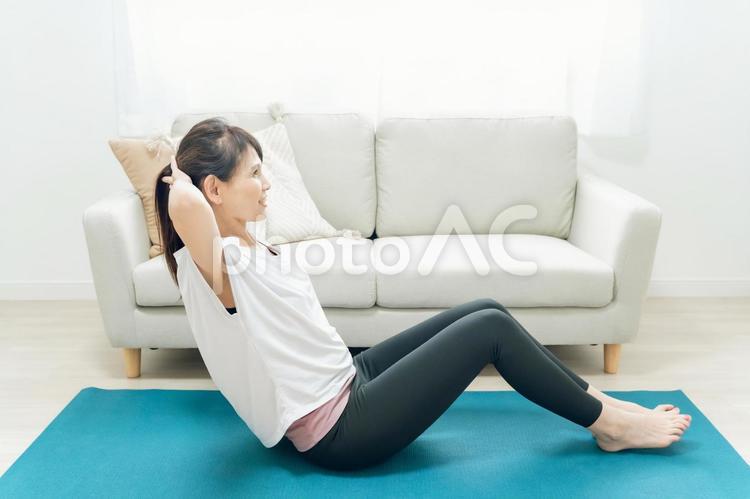 部屋で腹筋をするミドル世代の女性 腹筋,筋肉,お腹の写真素材