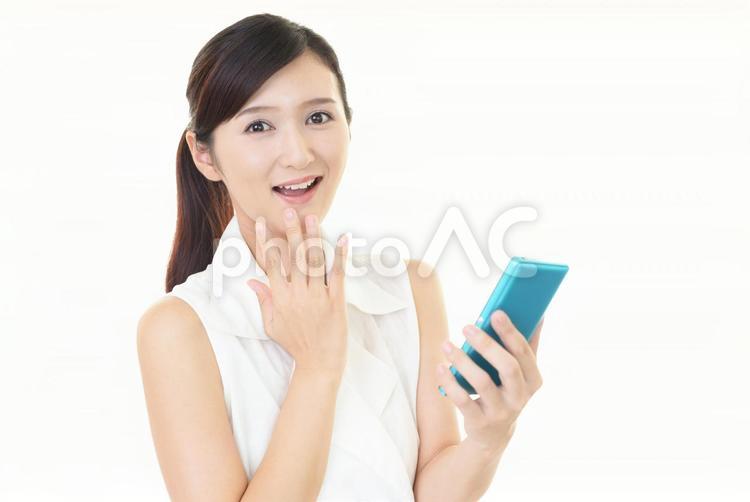スマートフォンを持つ笑顔の女性 女性,スマートフォン,女の写真素材