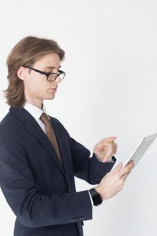 タブレットを使う横向きのスーツにメガネの男性 男性,外国人,欧米人の写真素材