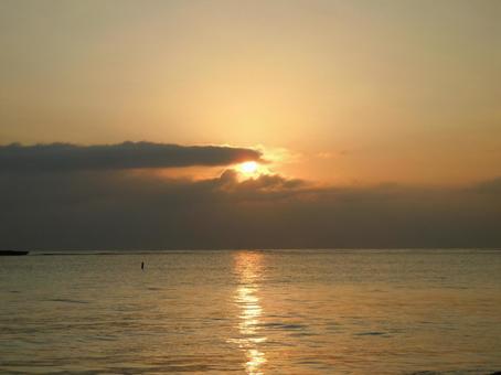 雲の間から見えるオレンジ色の夕日 雲の間から見えるオレンジ色の夕日 夕日,雲,海の写真素材