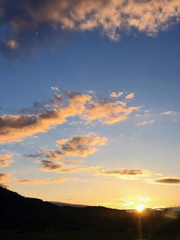 山に夕日が沈む光景 山に夕日が沈む光景の写真
