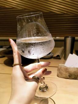グラスを持つ女性の手 ひとり飲み,一人飲み,カウンターの写真素材
