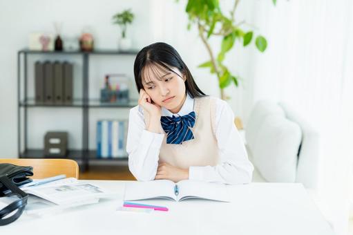 自宅で勉強中に悩む女子高生 自宅で勉強中に悩む女子高生の写真