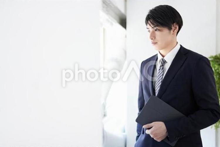 真剣な表情で窓の外を見るビジネスマン ビジネス,男性,ビジネスマンの写真素材