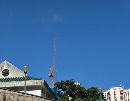 青空の下にそびえるクレーンと街の風景 クレーン,建設,青空の写真素材