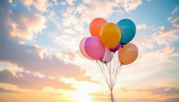 夕焼け空に舞うカラフルな風船の写真