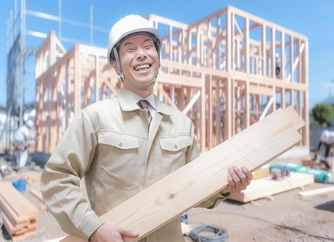 木材を持ち笑顔を見せる作業服の男性 男性,設計,技術者の写真素材