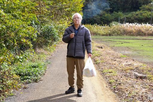 買い物帰りに歩きタバコをする老人 老後,シニア,タバコの写真素材