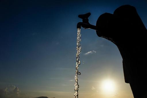＜素材＞夕暮れの水道から流れる水と水滴 サンセット,日の出,日没の写真素材