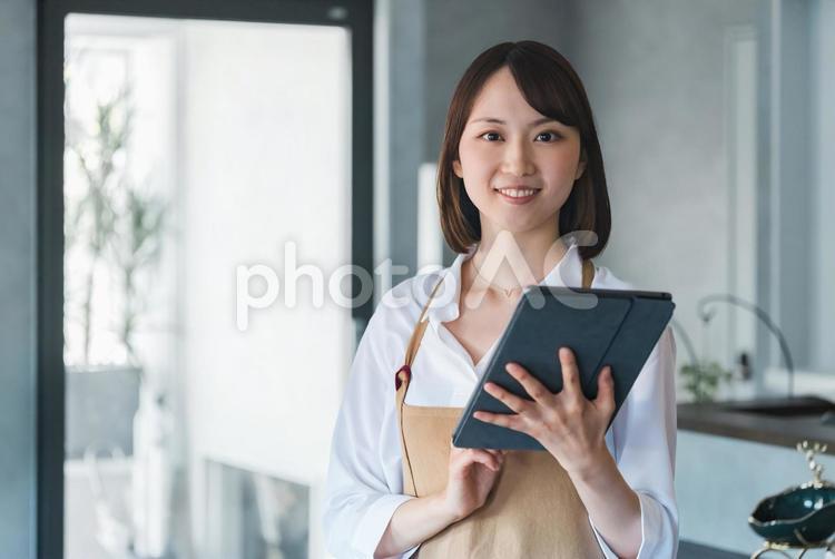 タブレットを持つ笑顔のカフェスタッフ 女性,ビジネス,ビジネスウーマンの写真素材