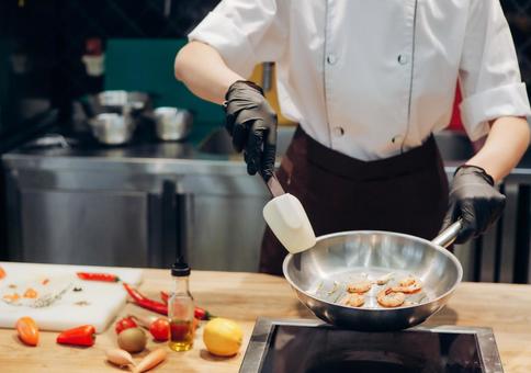 フライパンでエビを焼いている女性シェフの体 フライパンでエビを焼いている女性シェフの体 キュイジーヌ,キッチン,厨房の写真素材
