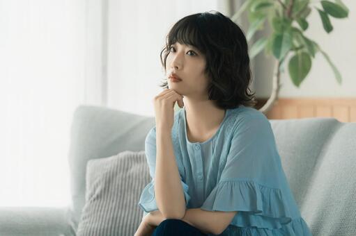 ソファに座って考えごとをする女性 女性,人物,考えるの写真素材