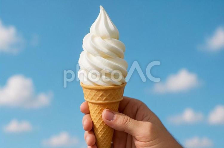 手に持ったソフトクリームと青空の背景 食べ物,ソフトクリーム,デザートの写真素材