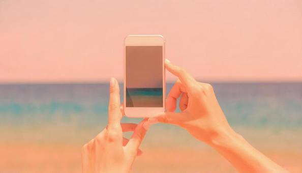 海を撮影するスマホと手 海を撮影するスマホと手の写真