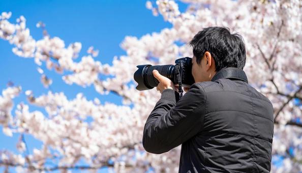 レンズを向ける日本人男性カメラマン レンズを向ける日本人男性カメラマンの写真